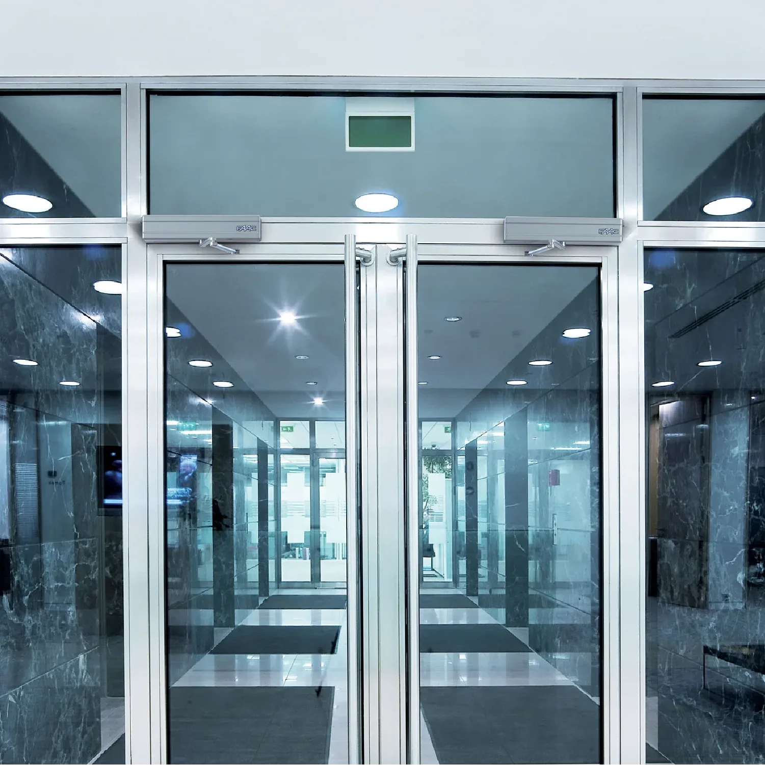 Portes automatiques battantes vitrées dans le hall d'un immeuble de bureaux à Paris